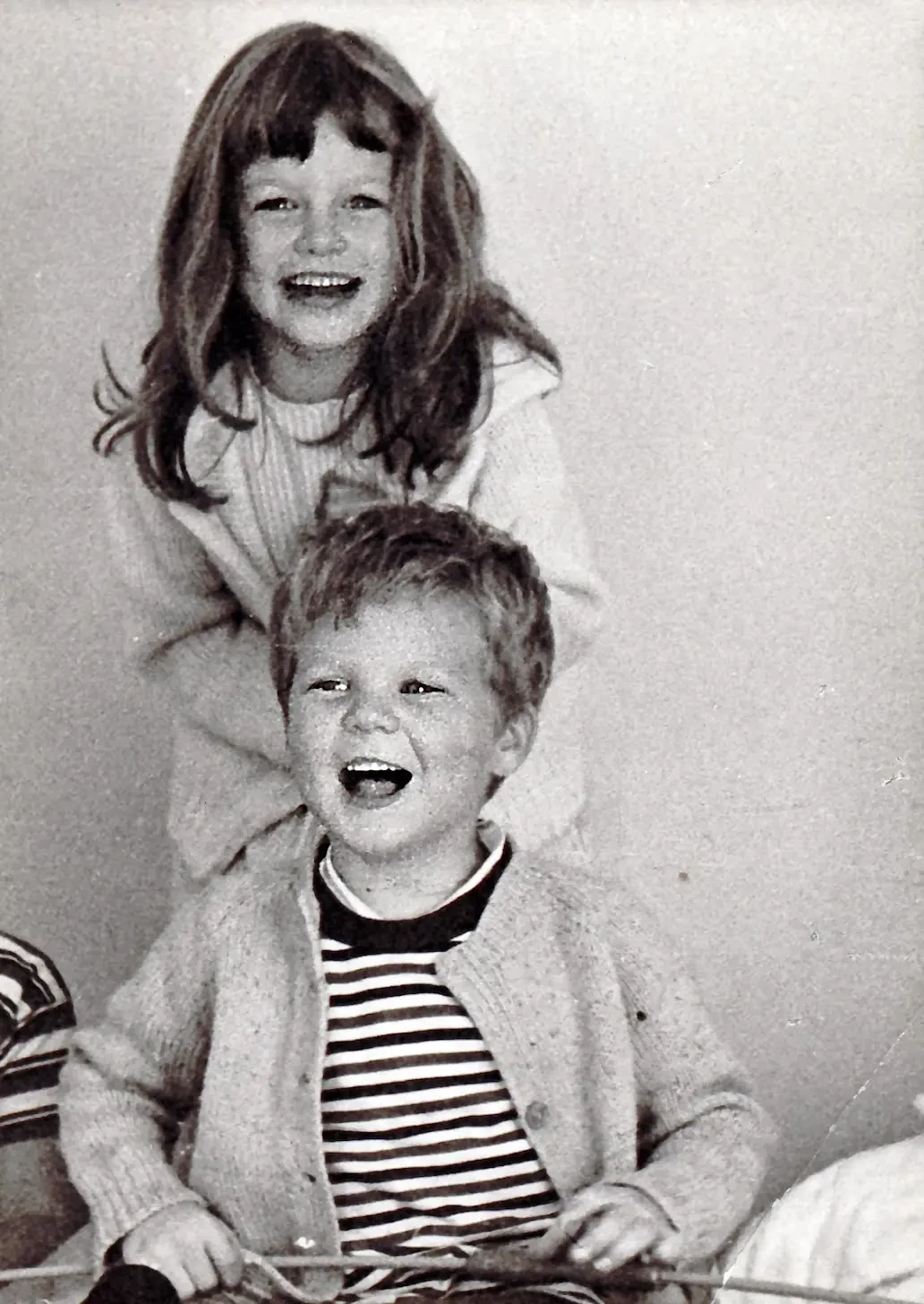 Young Anne and her brother Jeff laughing together as kids