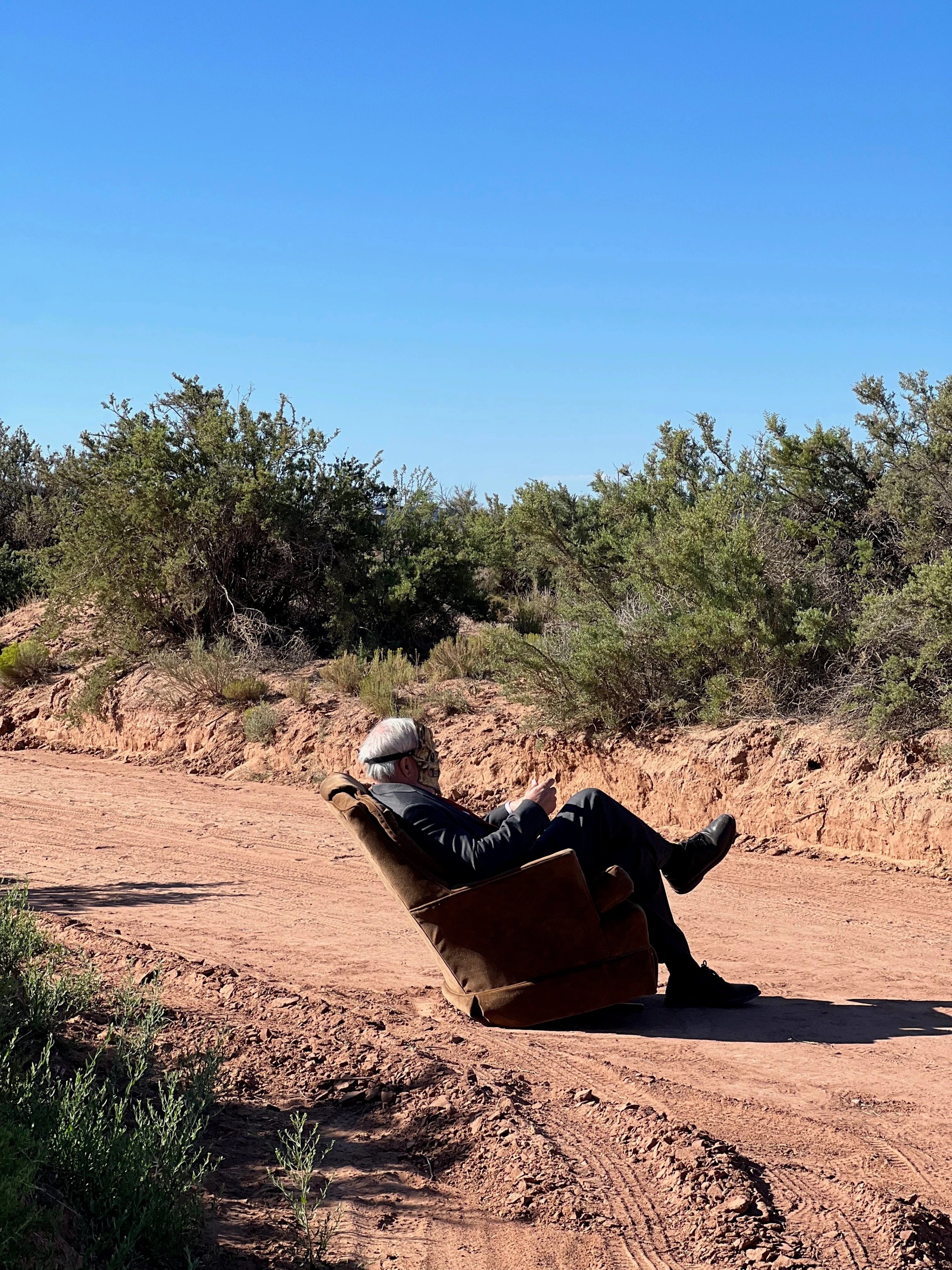 Tim in a recliner chair in the desert — F**k Your Face